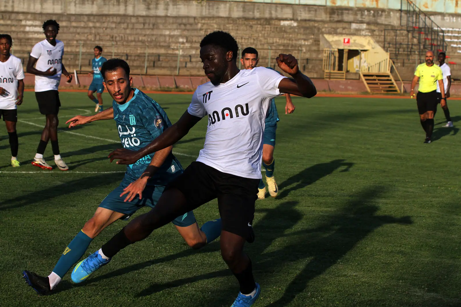 Vaune player and Al Wahn opponent competing for the ball
